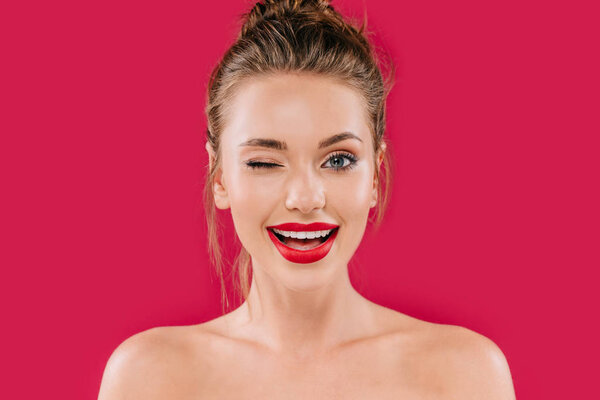 smiling naked beautiful woman with red lips winking isolated on red