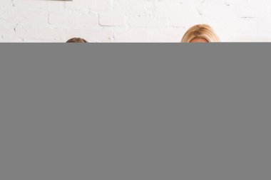 Gülümseyen çift kahvaltı yapıyor ve erkek yatakta gazete okuyor.