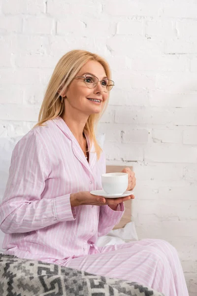 Smiling Woman Pajamas Eyeglasses Holding Coffee Cup Bedroom — Stock Photo, Image