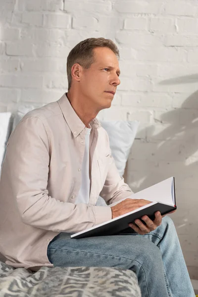 Thoughtful Man Holding Notebook Looking Away Bed — Stock Photo, Image
