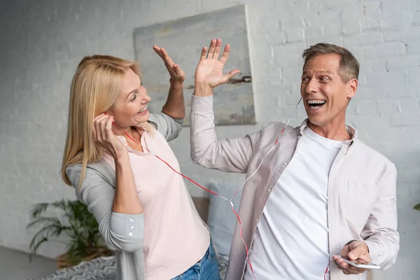 Uśmiechnięta Para Słuchawkach Przybija Piątkę Słuchając Muzyki — Zdjęcie stockowe