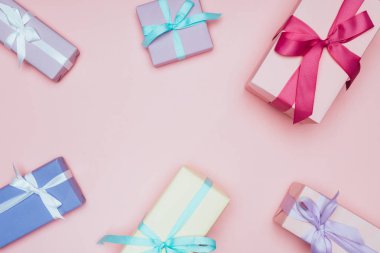 Pembe üzerine izole edilmiş, fiyonklu hediye kutuları.
