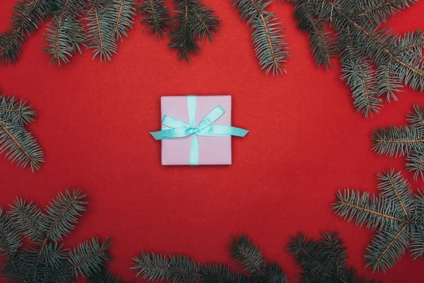 Ansicht Eines Weihnachtsgeschenks Mit Fichtenzweigen Auf Rot — Stockfoto