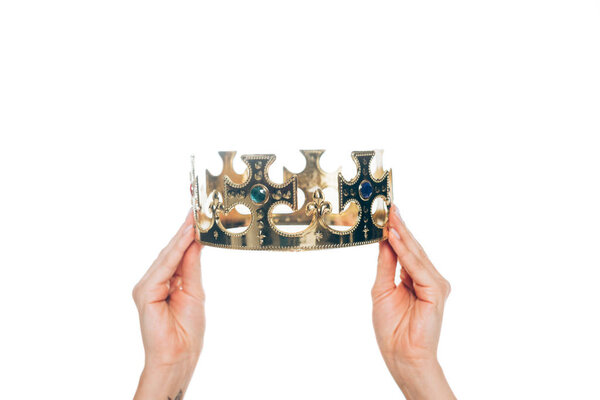 cropped view of woman holding golden crown with gemstones, isolated on white