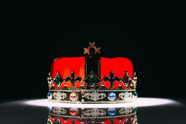 antique red golden crown with gemstones on black