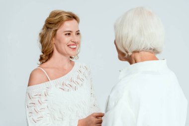 Gri üzerine izole edilmiş gülümseyen kızı seyreden annenin arkası. 