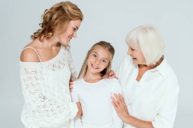 Gülümseyen anne, büyükanne ve torun griye sarılıyor. 
