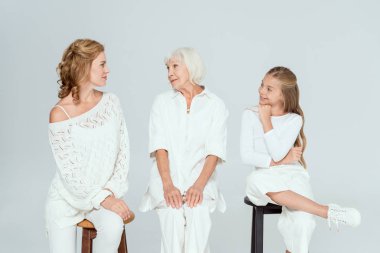 Gülümseyen torun, anne ve büyükanne Grinin üstünde birbirlerine bakıyorlar 