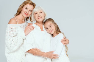 Gülümseyen torun, anne ve büyükanne sarılıyor. 