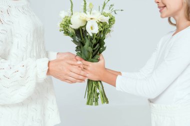 Gri yolda annesine buket veren gülümseyen kız manzarası. 