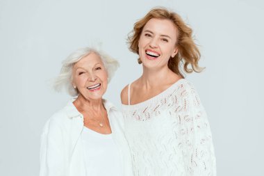 Gülümseyen anne ve kızı gri kameraya bakıyor. 