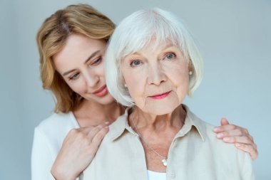 Gülümseyen kız sarılıyor ve Grey 'de izole edilmiş annesine bakıyor. 