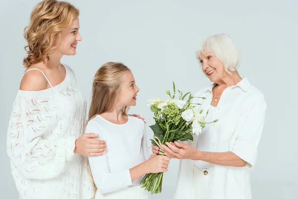 Smiling Granddaughter Giving Bouquet Grandmother Isolated Grey — Stock Photo, Image