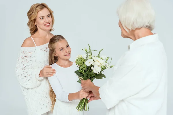 Smiling Granddaughter Giving Bouquet Grandmother Isolated Grey — Stock Photo, Image