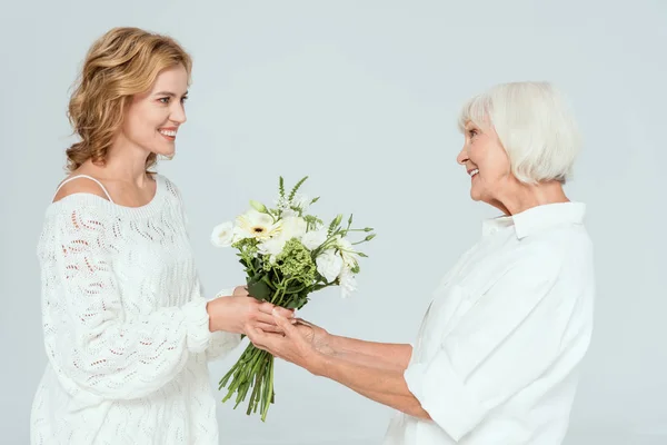 Smiling Daughter Giving Mother Bouquet Isolated Grey — Stock Photo, Image