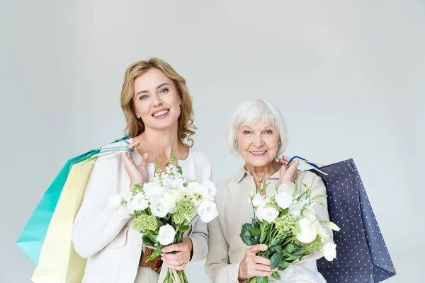 Lächelnde Mutter Und Tochter Mit Einkaufstaschen Und Blumensträußen Grau — Stockfoto