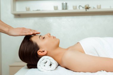 Masörün kaplıcada çekici bir kadına yüz masajı yapması. 