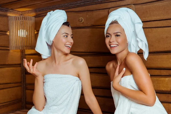 Uśmiechnięci Atrakcyjni Przyjaciele Ręcznikach Rozmawiający Saunie — Zdjęcie stockowe