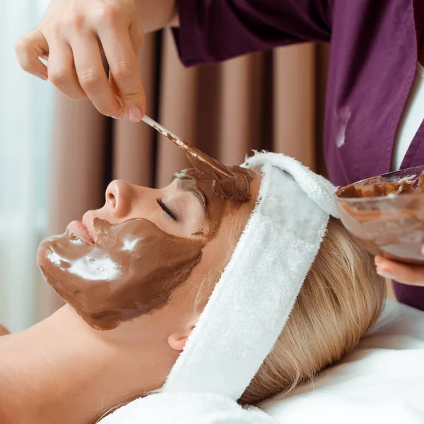 Abgeschnittene Ansicht Von Kosmetikerin Die Gesichtsmaske Auf Attraktive Frau Spa — Stockfoto