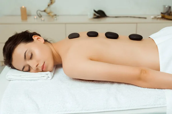 Mulher Atraente Com Pedras Quentes Nas Costas Deitado Mesa Massagem — Fotografia de Stock