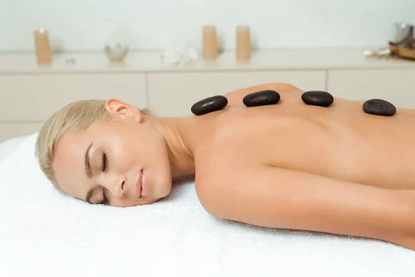 Mujer Sonriente Con Piedras Calientes Espalda Acostada Mesa Masaje Spa — Foto de Stock