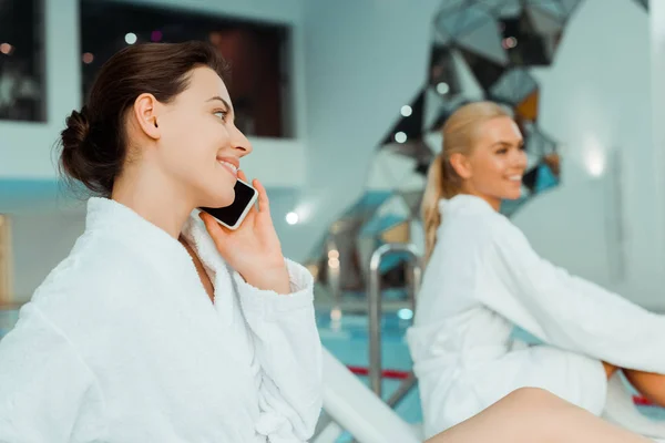 Enfoque Selectivo Mujer Atractiva Sonriente Hablando Teléfono Inteligente Amigo Fondo — Foto de Stock