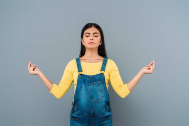 Gri renkte yalnız başına meditasyon yapan hamile güzel bir kız.