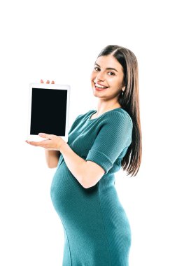 Beyaz ekranlı dijital tablet taşıyan gülümseyen hamile kız.
