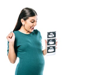 excited pregnant girl holding fetal ultrasound images isolated on white clipart