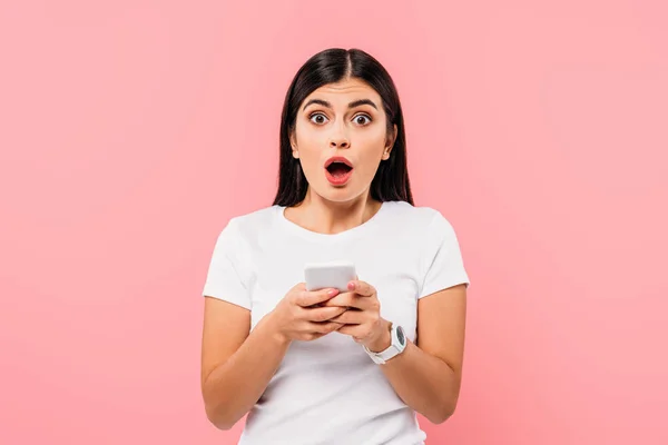 Geschokt Mooi Brunette Meisje Met Behulp Van Smartphone Geïsoleerd Roze — Stockfoto