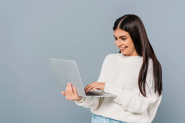 Uśmiechnięta Ładna Brunetka Dziewczyna Białym Swetrze Pomocą Laptopa Odizolowany Szary — Zdjęcie stockowe