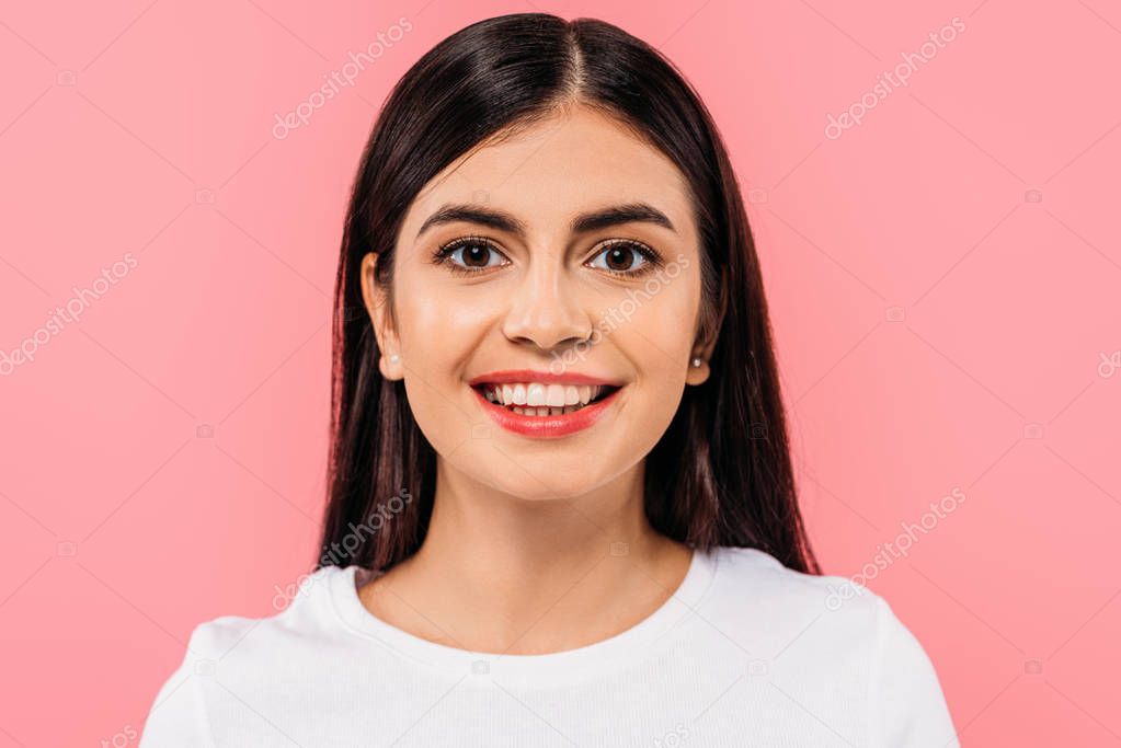 portrait of smiling pretty brunette girl isolated on pink