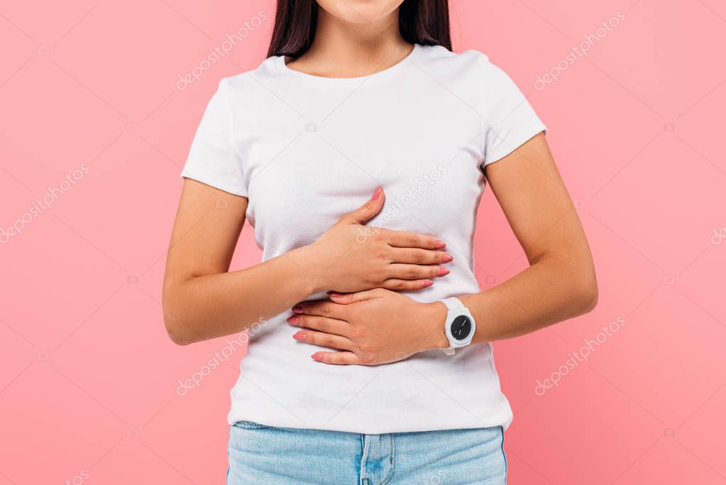 cropped view of girl suffering from stomachache isolated on pink