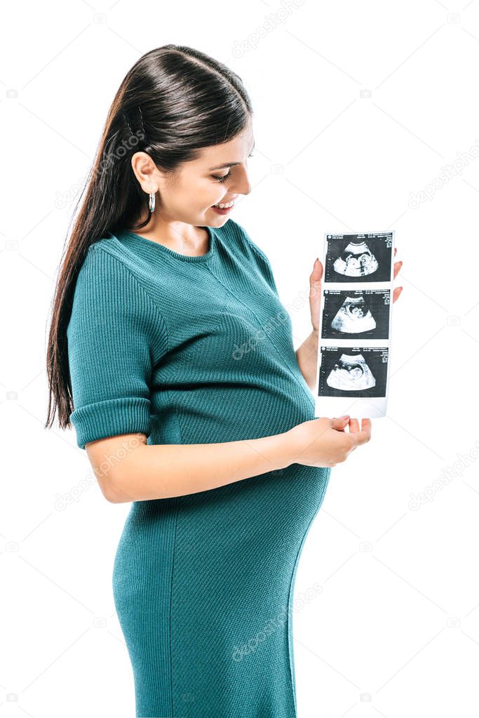 Smiling pregnant girl holding fetal ultrasound images isolated on white