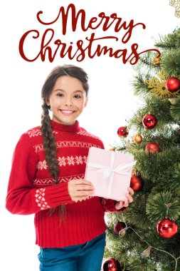 Noel ağacının yanında pembe hediyeler tutan neşeli çocuk mutlu noel mektuplarıyla beyaz üzerine izole edilmiş.