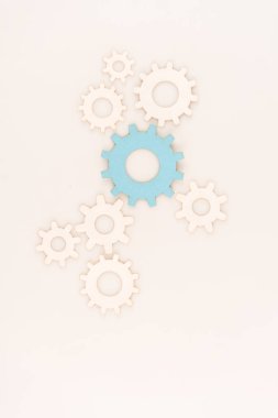 top view of one blue gear among another isolated on white clipart
