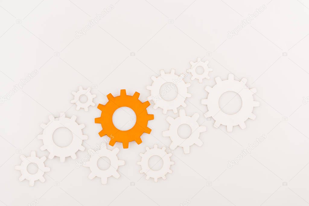 top view of one orange gear among another isolated on white