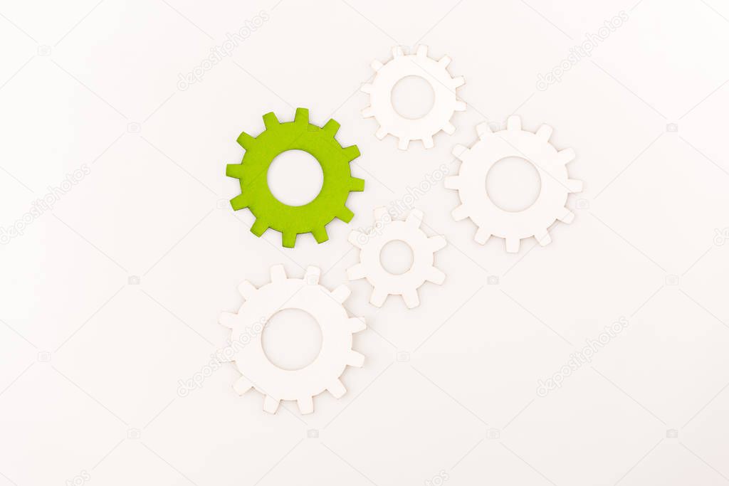 top view of one green gear among another isolated on white