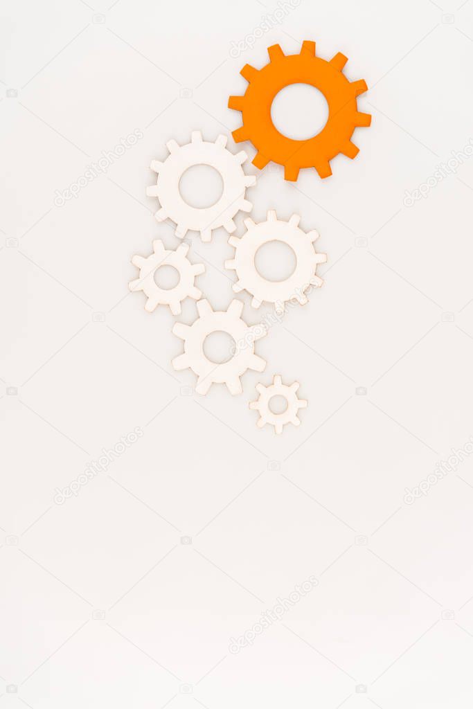 top view of one orange gear among another isolated on white