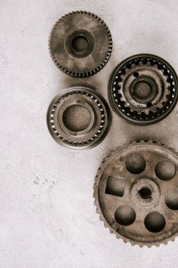 top view of aged metal round gears on grey background clipart