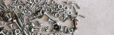 top view of metal screws and nails scattered on grey background, panoramic shot clipart