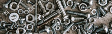 top view of metal screws and nails scattered on grey background, panoramic shot clipart
