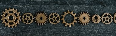 flat lay with vintage metal gears on dark wooden background, panoramic shot clipart