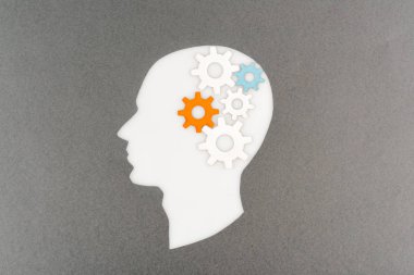 top view of cut out white human head with colorful gears isolated on grey clipart