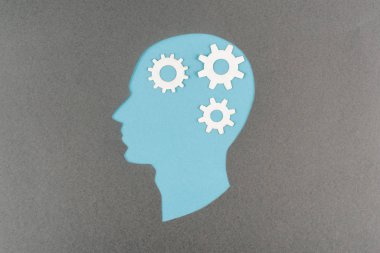 top view of cut out blue human head with white gears isolated on grey clipart