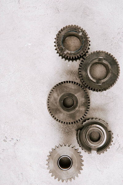 top view of aged metal round gears on grey background