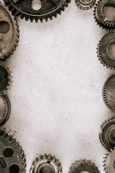 frame of aged metal round gears on grey background with copy space