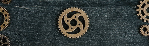 вид сверху на винтажный металлический механизм в рамке на темном деревянном фоне, панорамный снимок
