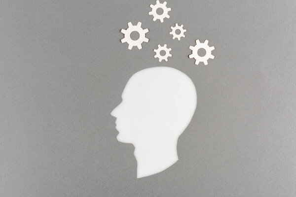top view of cut out white human head with gears isolated on grey