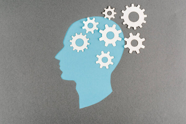 top view of cut out blue human head with white gears isolated on grey